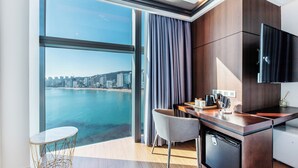 Una cucina moderna con vista sulla città e sull'acqua, un'area pranzo con tavolo e sedie, e un forno integrato.