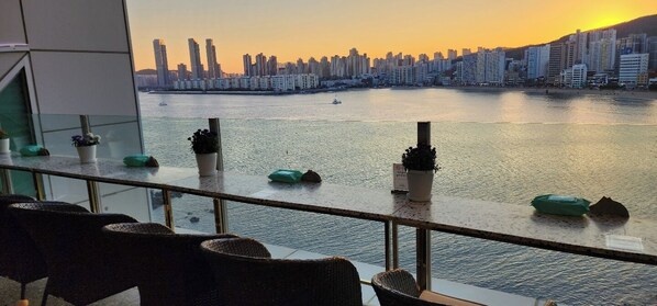 Vista desde un balcón sobre un cuerpo de agua con el perfil urbano al fondo.