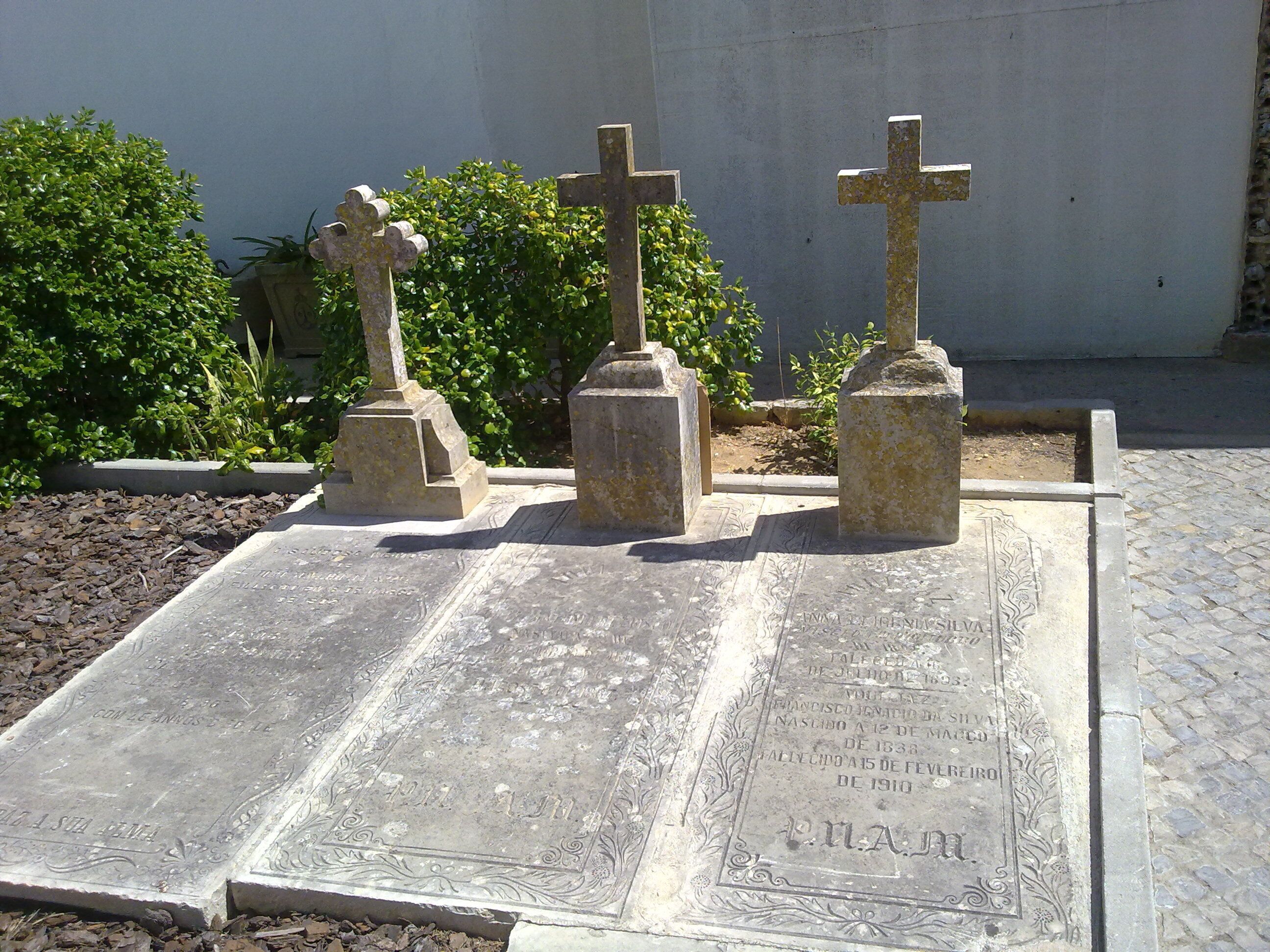 A cemetery with gravestones and inscriptions.