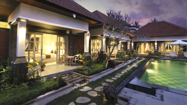 A modern resort with a swimming pool, well-maintained gardens, and a cozy outdoor seating area. - Uma Dhari Villa (Sukawati)
