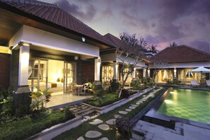 Un moderno complejo turístico con piscina, jardines cuidados y una zona de estar exterior acogedora.