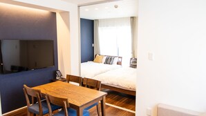 A compact living space with a dining area, a sofa, and a bed. - Apartment Hotel Tenjin Tumugu (Fukuoka)