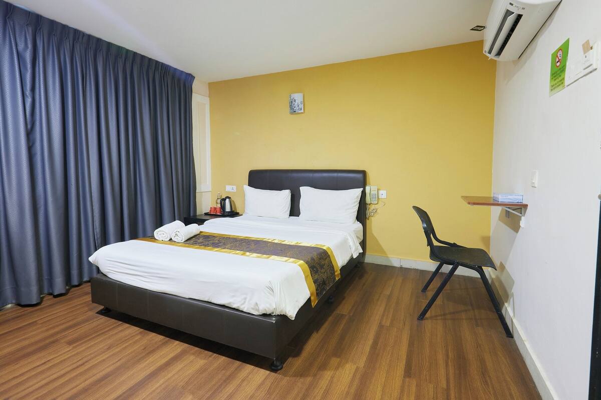 A hotel room with a bed, a chair, and a desk.