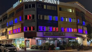 A multi-story building with a sign for 'SUNJOY 9 HOTEL' and 'MOZI KITCHEN' below. - Hotel Sunjoy9 OKR Near Midvalley 10 Mins Only (Kuala Lumpur)