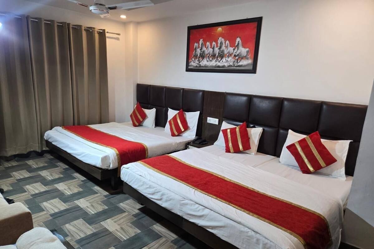 A hotel room with two beds, a large painting, and a patterned floor.