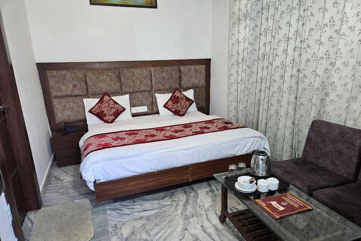 A bedroom with a bed, a coffee table, a sofa, and a small rug.