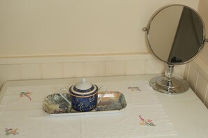 A bathroom with a white sink, a mirror, and a tray with a teapot and cup. - The Barns Country Guesthouse (Retford)