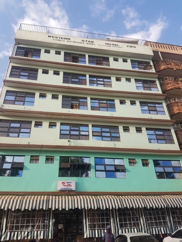 Un edificio de varios pisos con un cartel que indica que es un hotel.