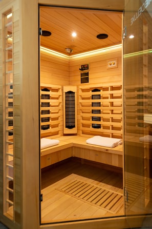 A sauna with wooden walls and benches, a control panel, and a ventilation system. - Apartmaji bungalovi i sotorisce Silva (Ljutomer)