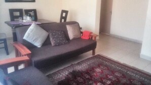 Ein Wohnzimmer mit einer Couch, einem Couchtisch und einem gemusterten Teppich.
