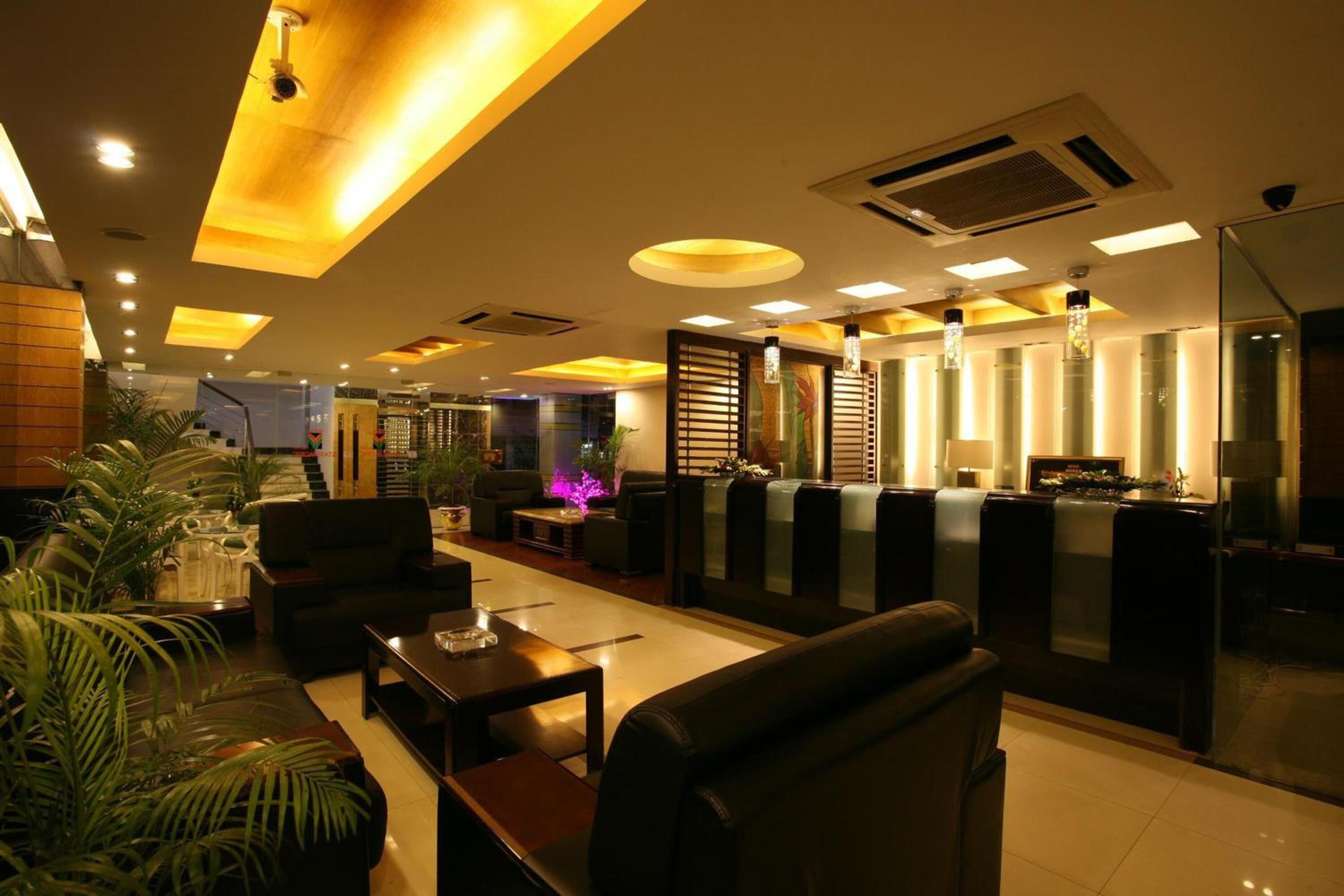 A modern hotel lobby with leather seating, a reception desk, and ambient lighting.