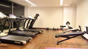 A gym with treadmills, ellipticals, and free weights.