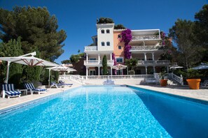 Una piscina al aire libre de temporada, sombrillas