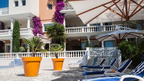 A poolside area with lounge chairs and potted plants. - Chambre d'hôtes La Potinière (Saint-Raphael)