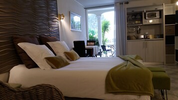 Un dormitorio con una cama grande, un comedor y vistas al exterior.