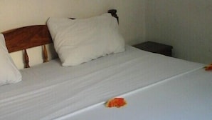 Ein Bett mit weißer Bettwäsche und einem Holzkopfteil.