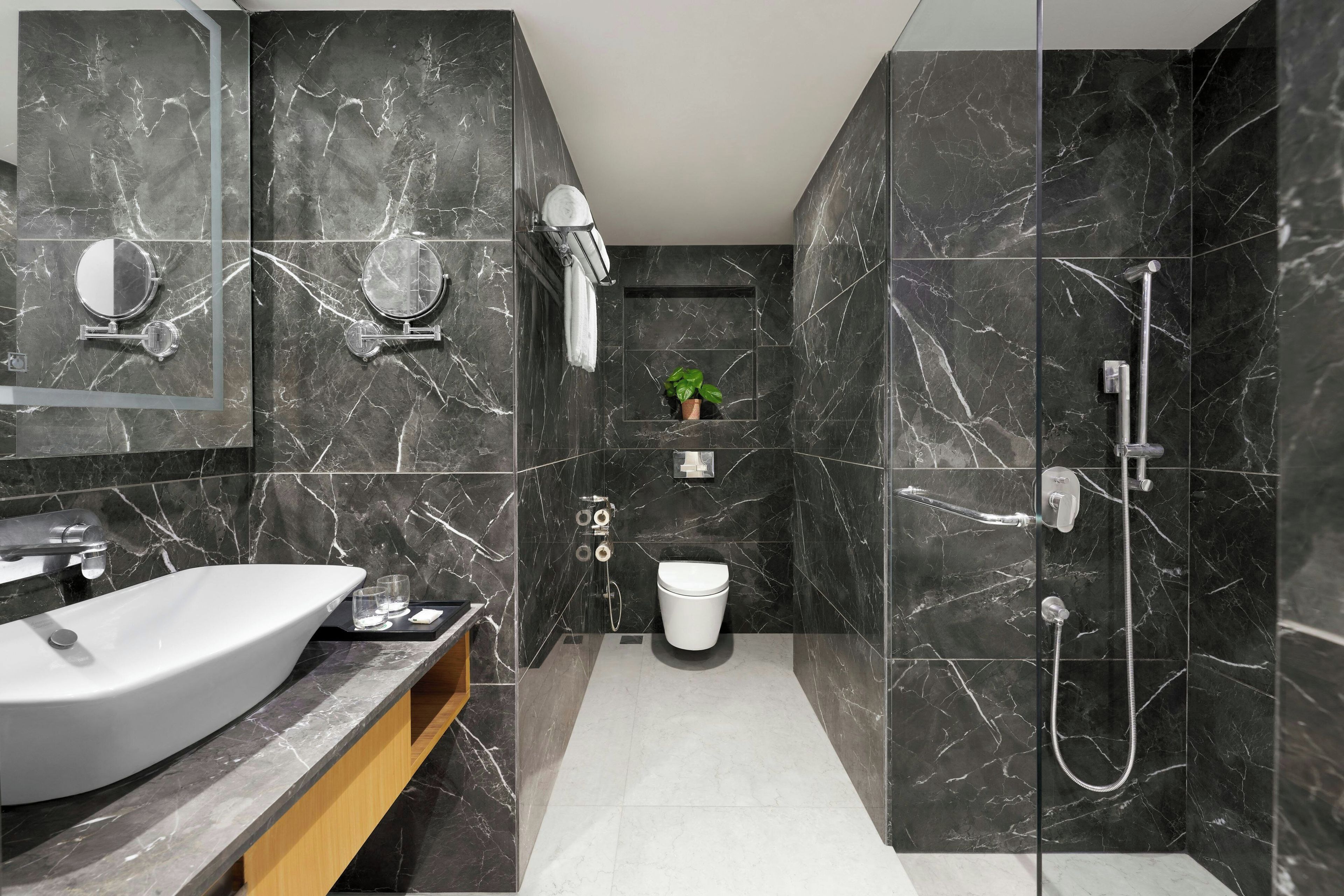 Un baño moderno con un lavamanos grande, espejo y ducha.