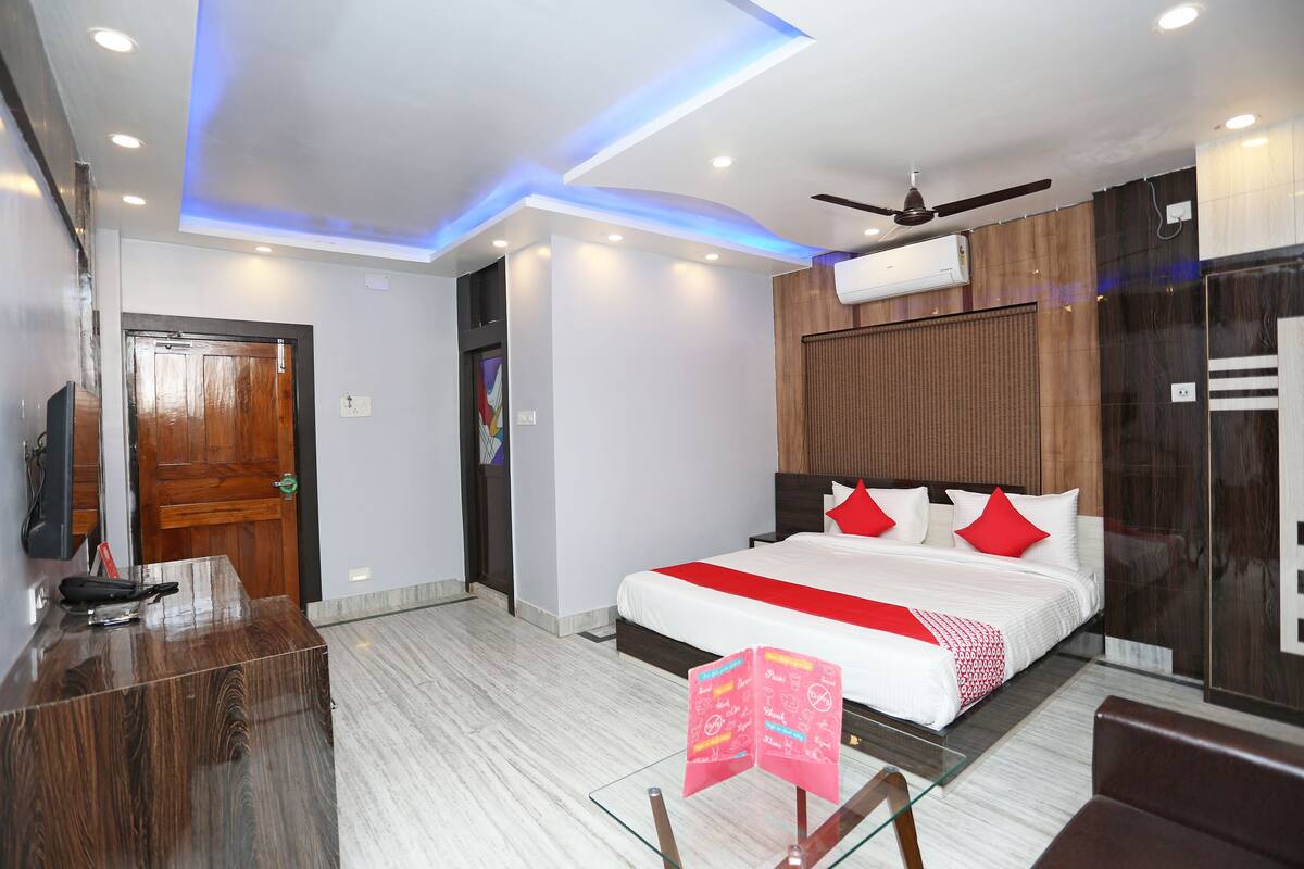 Ein modernes Hotelzimmer mit einem großen Bett, einem Schreibtisch und einem Deckenventilator.