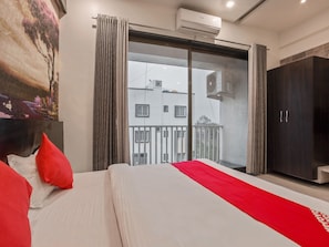 Une chambre d’hôtel comprenant un lit, une armoire, un balcon et un appareil de climatisation.