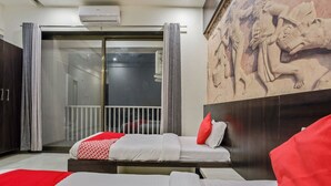 Una habitación de hotel con una cama, un balcón y un mural en la pared.