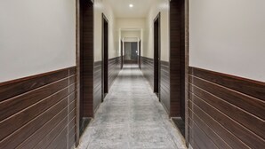 Un pasillo largo y estrecho con paneles de madera oscura en las paredes y suelo de baldosas.