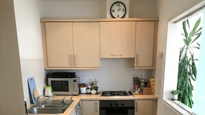 Eine kompakte Küche mit Mikrowelle, Herd, Backofen und Spüle.