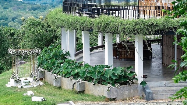 A pool area with a view of mountains, a covered seating area with a pergola, and a stone pathway leading to a gazebo. - Arangala Forest Lodge (Naula)