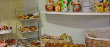 Un bufé de desayuno con diversos pasteles, pan y diferentes opciones para untar.