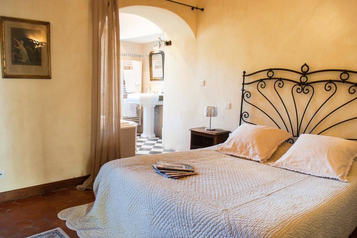 Ein Schlafzimmer mit Bett, Nachttisch, Lampe und einem gerahmten Bild an der Wand.