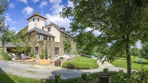 Ein Steinhaus mit Terrasse, einem kleinen Garten und Blick auf die umliegende Landschaft.