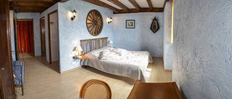 Une chambre à coucher avec un lit en bois, une chaise, une horloge murale et une porte.