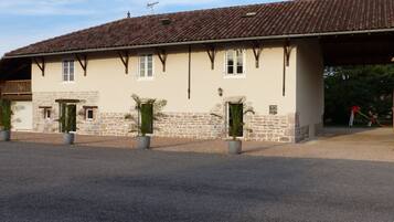 A two-story building with a stone facade, multiple windows, and a tiled roof.