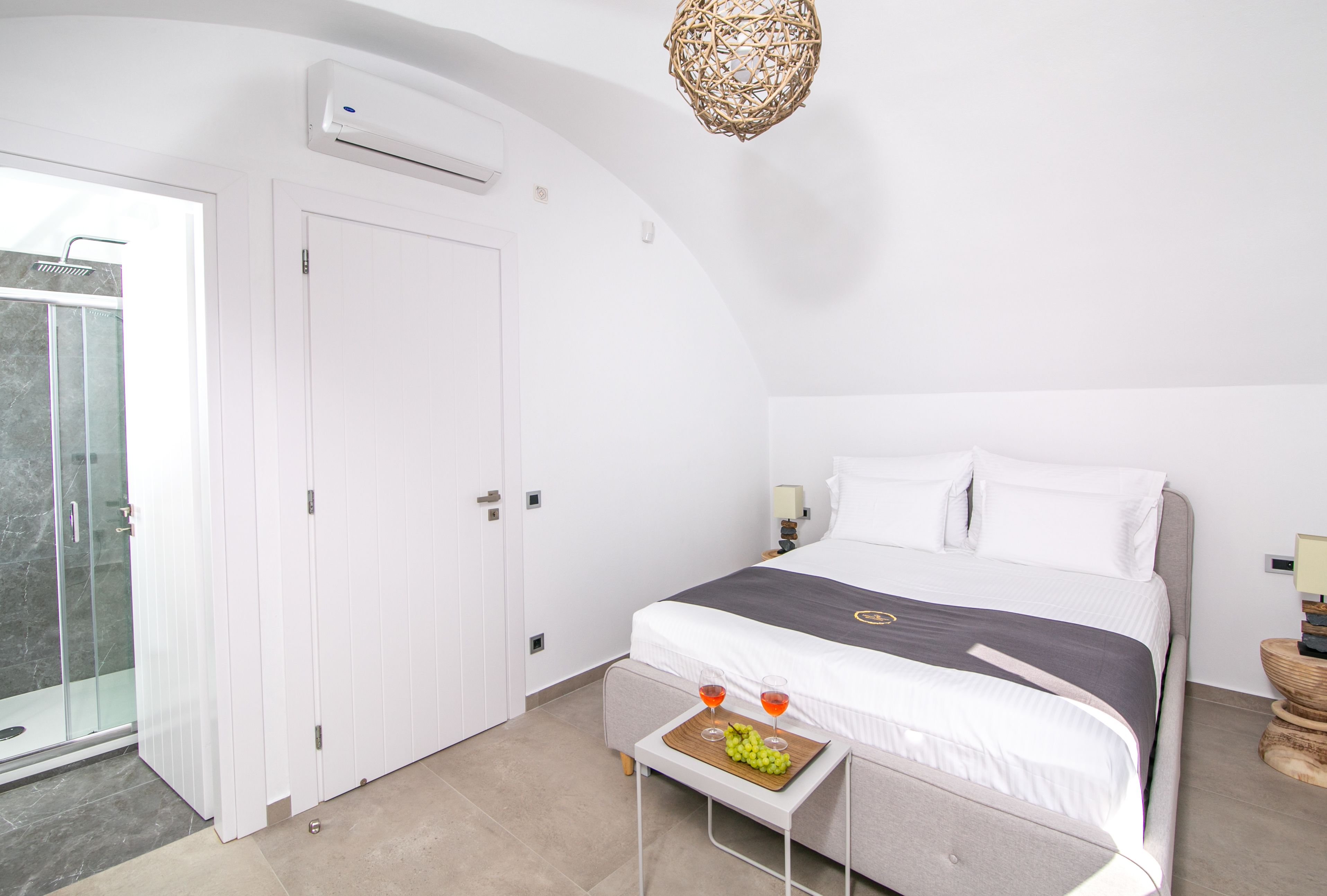 A bedroom with a bed, bedside tables, a wardrobe, and a shower area.