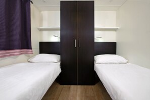 A room with two single beds, a dark wardrobe, and a window with curtains. - Amadria Park Camping Mobile Homes  (Sibenik)