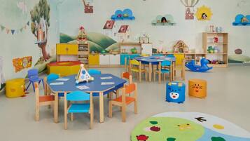 A children's playroom with colorful furniture, educational toys, and playful wall decorations.