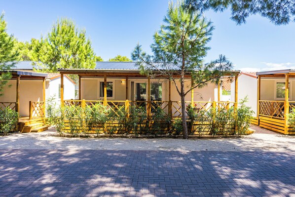 A row of cabins with wooden railings and a gravel driveway. - Amadria Park Camping Mobile Homes  (Sibenik)