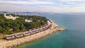 A coastal area with a row of mobile homes along a rocky shoreline.