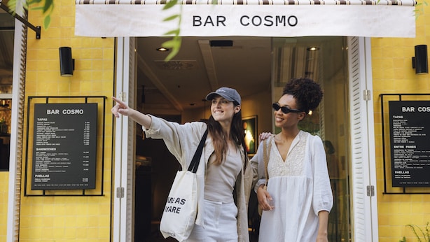 Entrada a un restaurante con un letrero que dice "BAR COSMO".