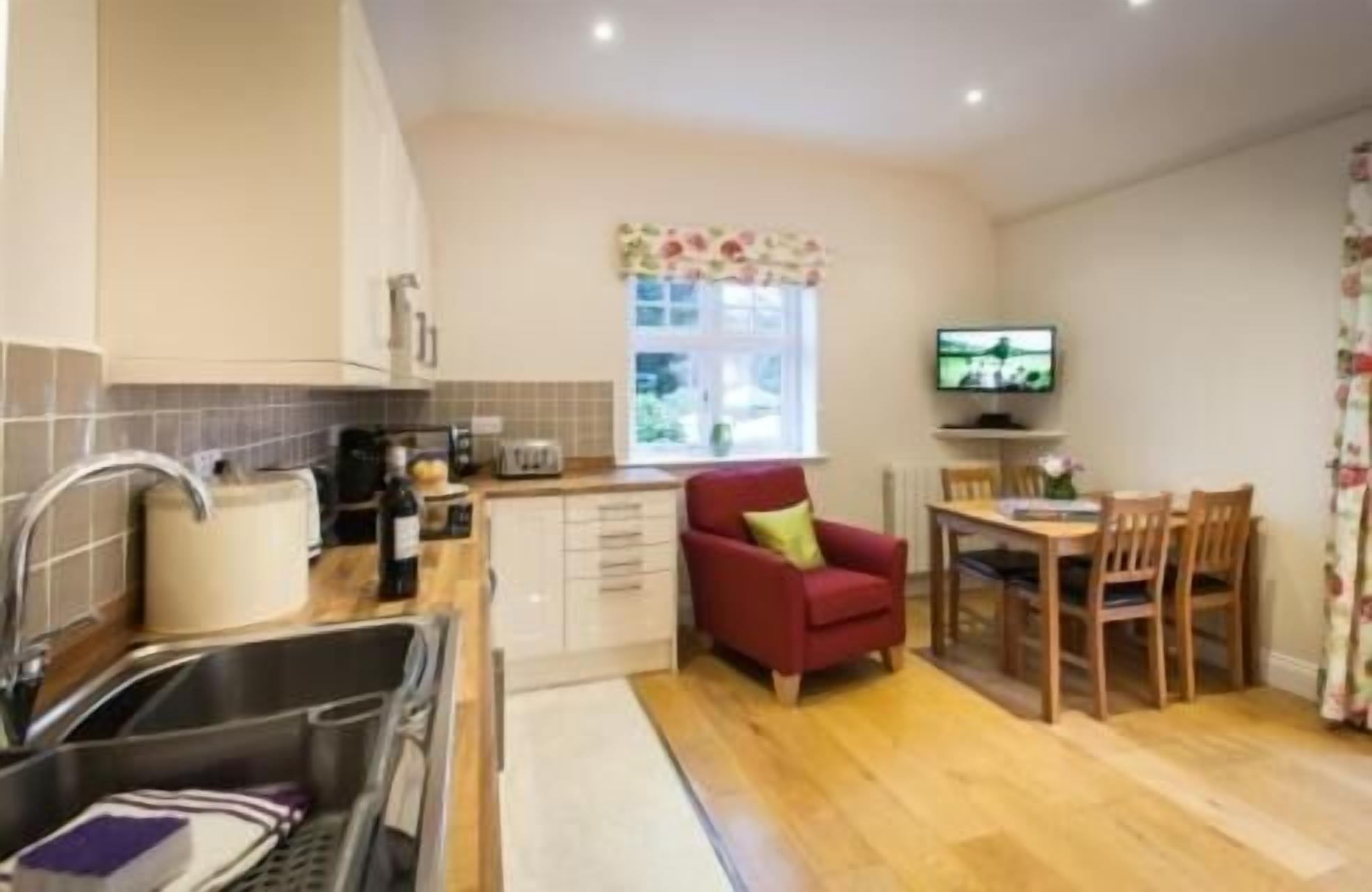 A compact kitchen with a sink, toaster, and window.