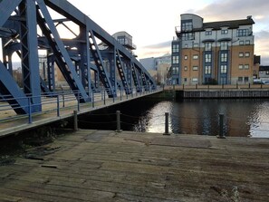 A blue metal bridge over a canal with a wooden walkway. - Constitution Apartments (Edinburgh)