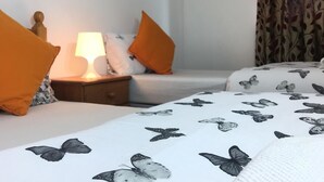 A hotel room with a bed, a nightstand with a lamp, and a window with curtains.