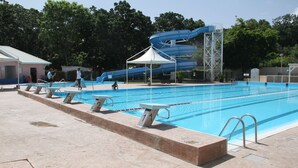 A swimming pool with numbered lanes, a water slide, and a covered area. - Beach 100m away ▪ Sea view ▪ Apartment classified 3*quiet▪ garden with trees ▪1 bedroom (Le Moule)