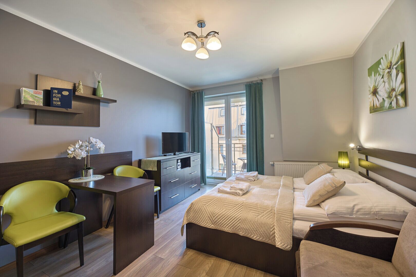 Une chambre d’hôtel équipée d’un lit, d’un bureau, d’une chaise, d’une télévision et offrant une vue sur l’extérieur.