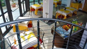 A restaurant with outdoor seating, a glass railing, and a fruit display. - Residence Rivaverde (Ravenna)