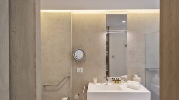 A modern bathroom with a white sink, mirror, and towel rack.