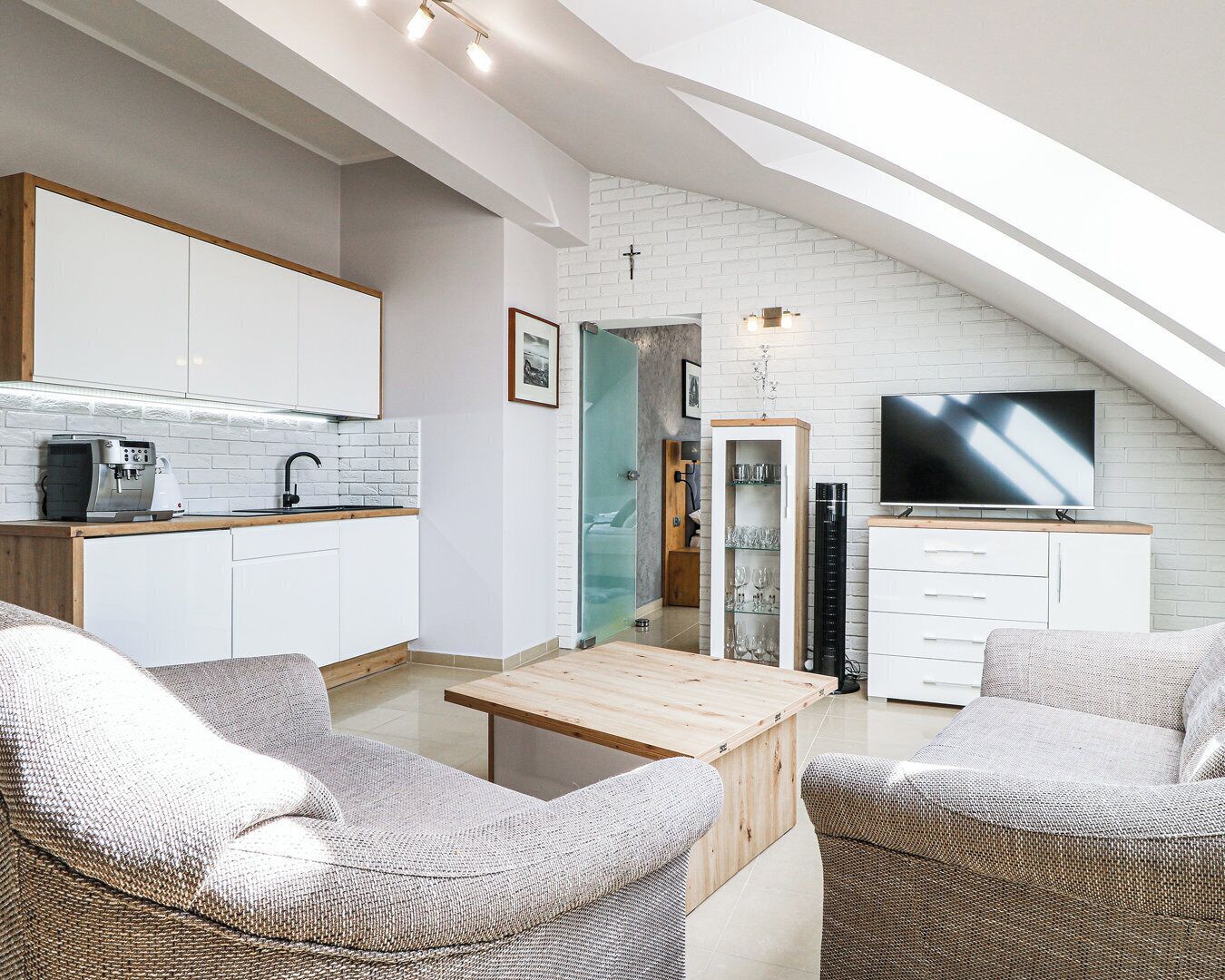 En modern lägenhet i loftstil med kök, matplats och vardagsrum.