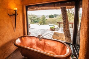 A bathroom with a large window, a bathtub, and a wooden deck outside. - Garonga Safari Camp (Phalaborwa)
