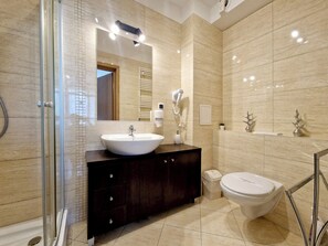 Suite estudio estándar, 1 cama Queen size y sofá cama | Baño | Regadera, secadora de cabello, toallas, papel de baño