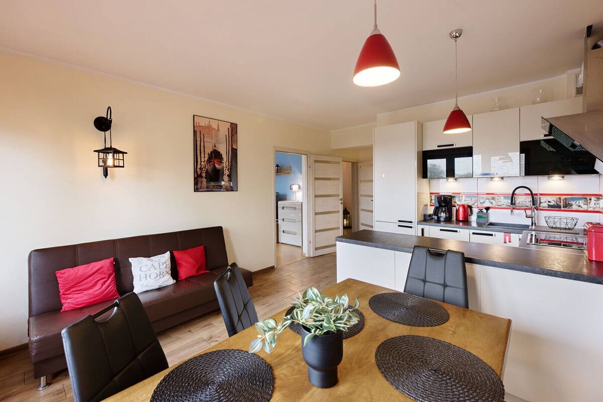 A modern apartment with a dining area, kitchen, and living room.