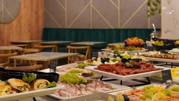 Un buffet proposant une variété de plats, notamment des viandes, des salades et d’autres mets.